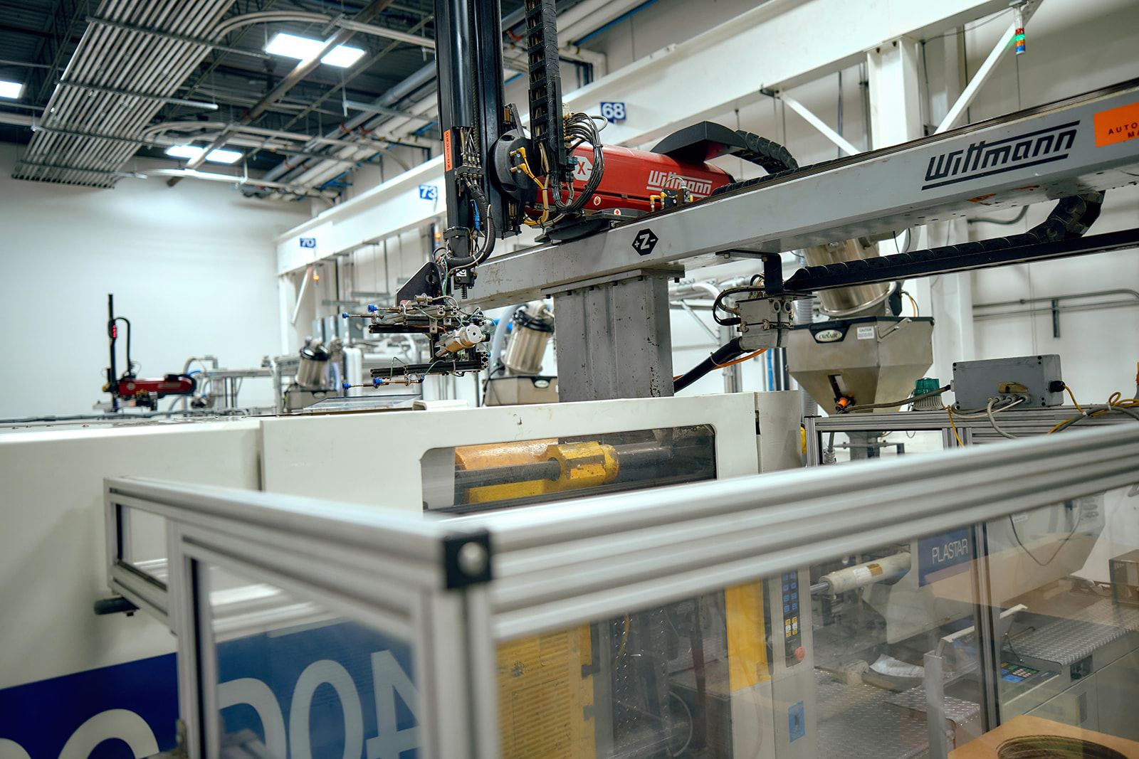 Black automotive interior trim and under-hood injection-molded plastic components on a workbench