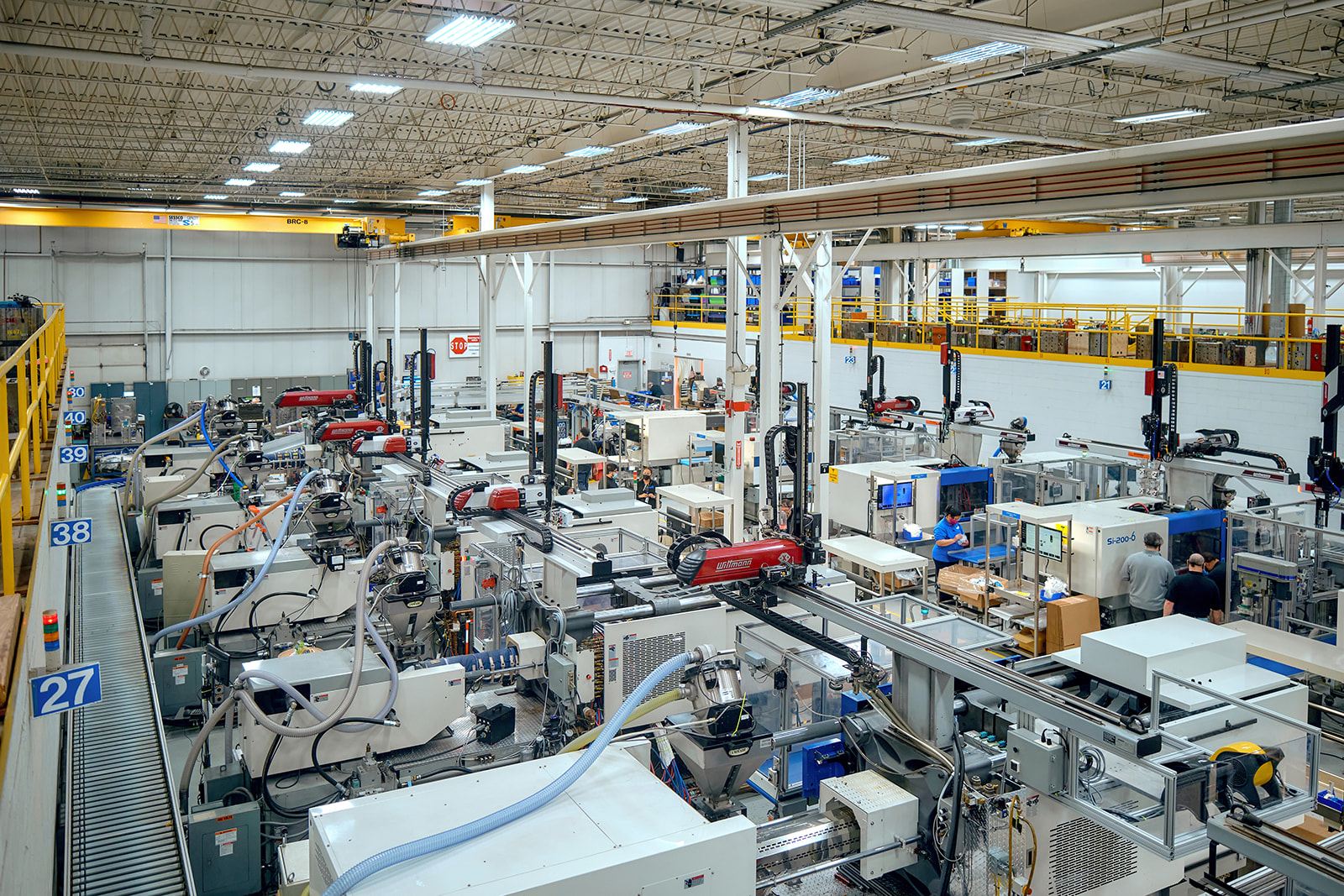 Heavy-duty injection-molded industrial equipment housings and structural enclosures in a factory